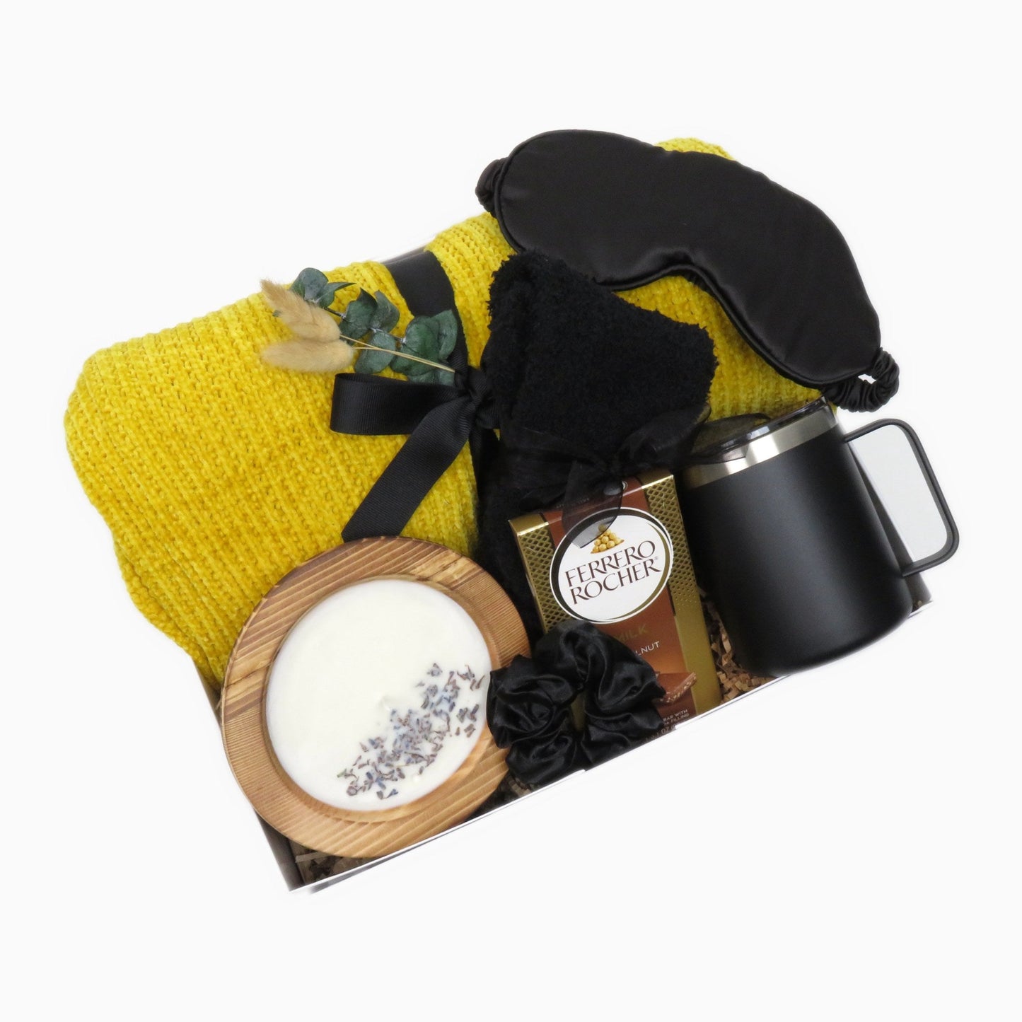 Cozy relaxation gift box with a yellow chenille knit throw, black satin sleep mask, insulated mug, and lavender soy candle